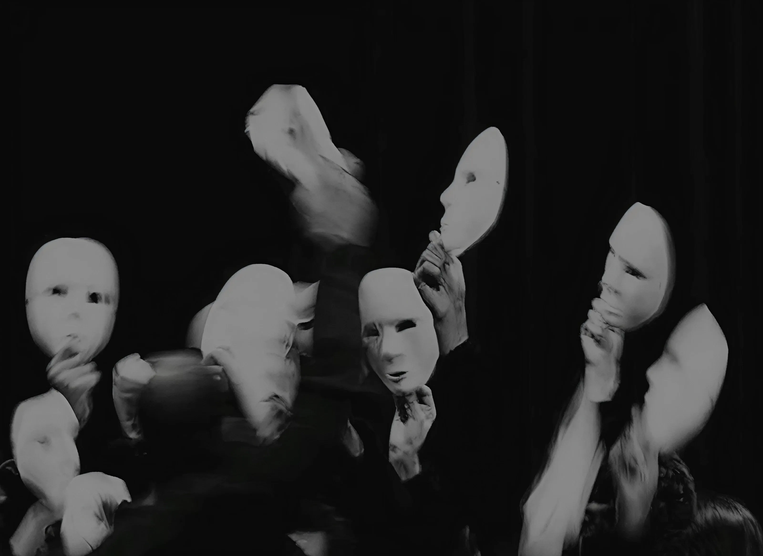 White masks held before faces in motion blur